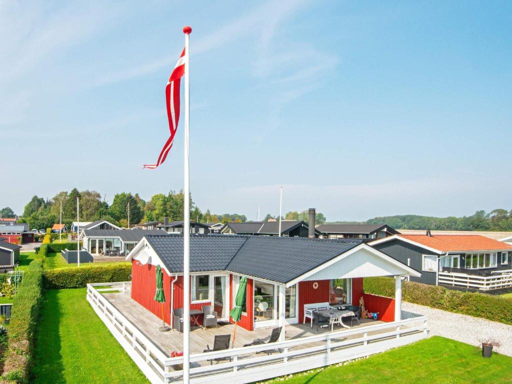 森讷比6 person holiday home in Juelsminde的前面有旗帜的房子