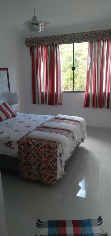 卢米亚Casa de Campo em Lumiar com corrego ,lareira e churrasqueira的一间卧室设有一张床和一个窗口