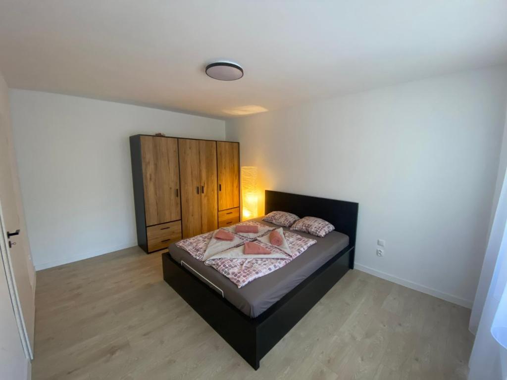 什图罗沃Apartmán Kristína的一间卧室配有一张床和一个木制橱柜