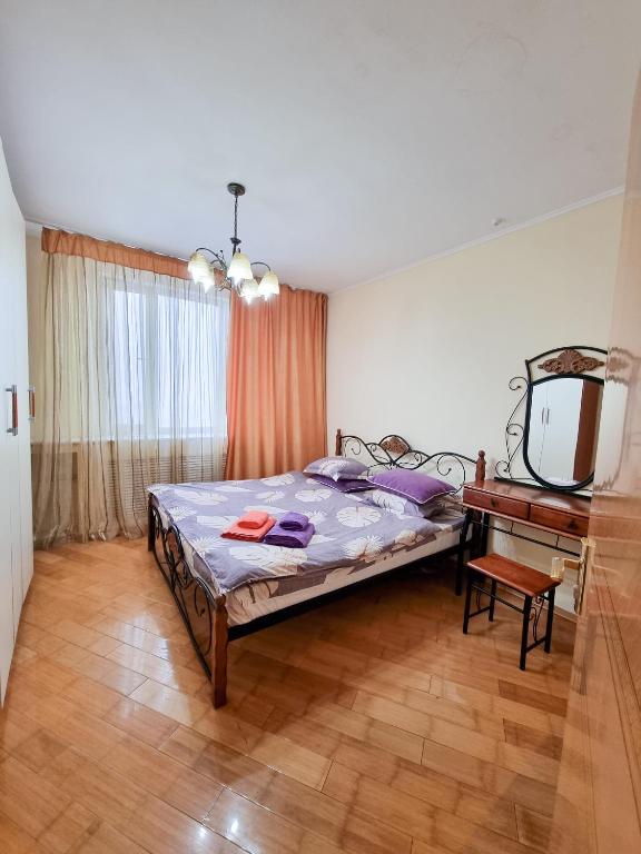 阿斯塔纳Квартира的一间卧室配有一张床、一张桌子和一面镜子