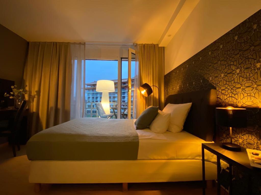 美因河畔法兰克福帕拉贡公寓式酒店的一间带大床的卧室和一个阳台