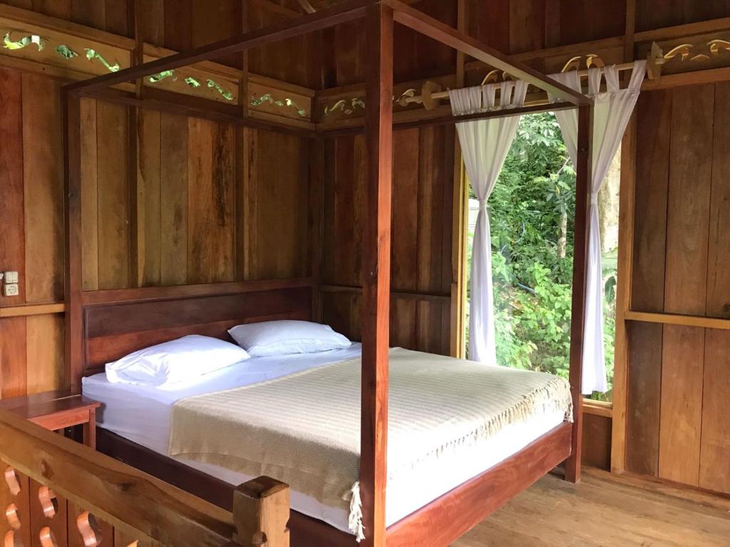 武吉拉旺Rambai Tree Jungle Lodges的木屋内设有一间带两张床的卧室
