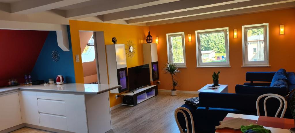 耶德利纳-兹德鲁伊Czas relaksu的客厅设有橙色墙壁和厨房