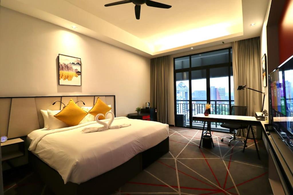 吉隆坡M101 KLCC KL city King Suites by Livin的一间卧室配有一张床、一张书桌和一台电视