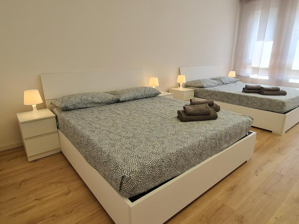 帕多瓦Infinity Collection的卧室内的两张床,配有两盏灯