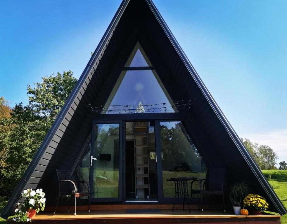 IeriķiRose Valley Cottage的三角形的房屋,设有玻璃窗