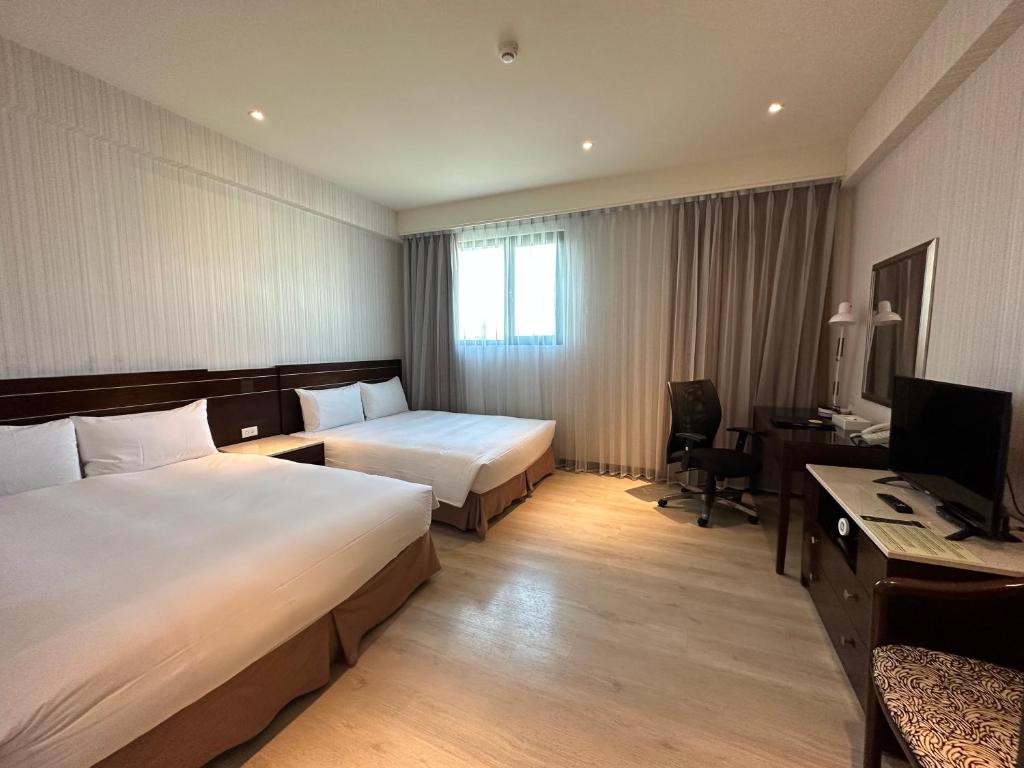 台南扬悦精致大饭店台南馆的酒店客房配有两张床和一张书桌