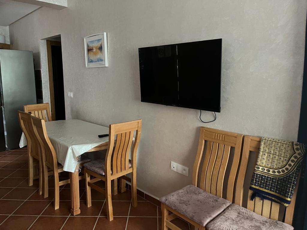 卡博尼格洛Luxury resident with pool的用餐室配有桌椅和墙上的电视