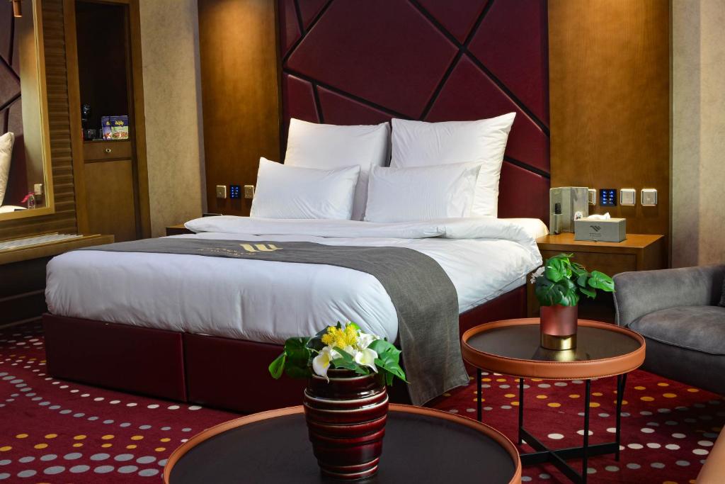 吉达Redwaves Hotel的酒店客房,配有床、椅子和桌子