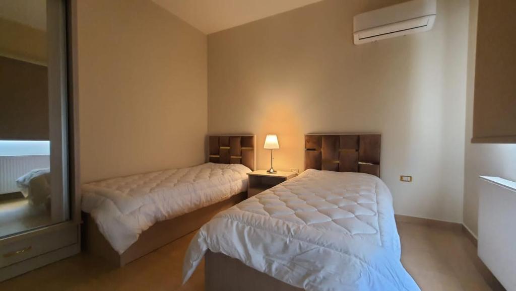 马达巴CMK Housing的一间卧室配有两张床和镜子