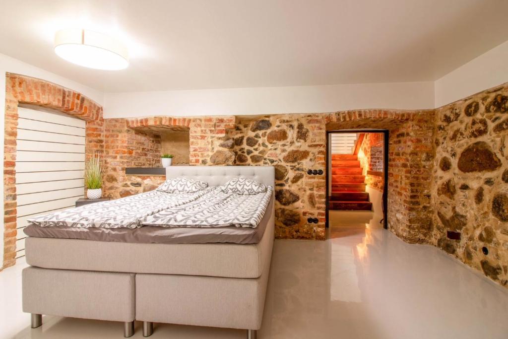 塔尔图Old Town Luxury apartment with sauna的一间卧室设有一张床和石墙
