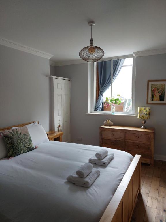 爱丁堡Portobello Charming Seaside 3-BR Holiday Apartment的一间卧室配有一张床,上面有两条毛巾