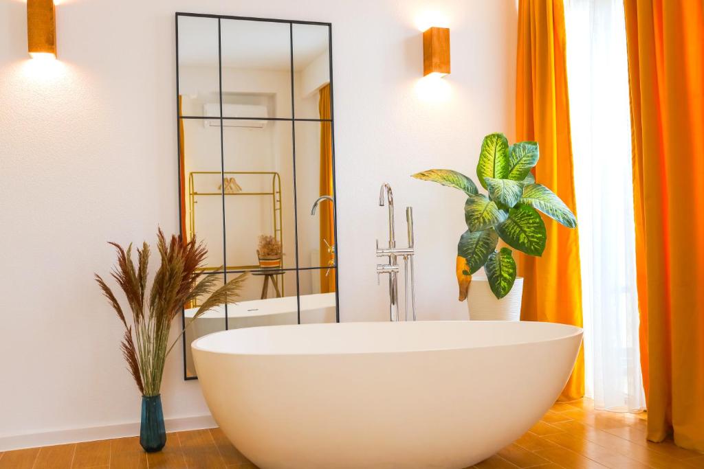 第比利斯Mohika Aparthotel的一间带大型白色浴缸和淋浴的浴室