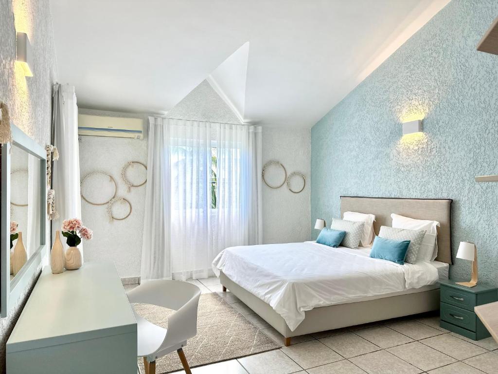 弗利康弗拉克Azur - Résidence Le Dattier的卧室配有白色的床和蓝色的墙壁