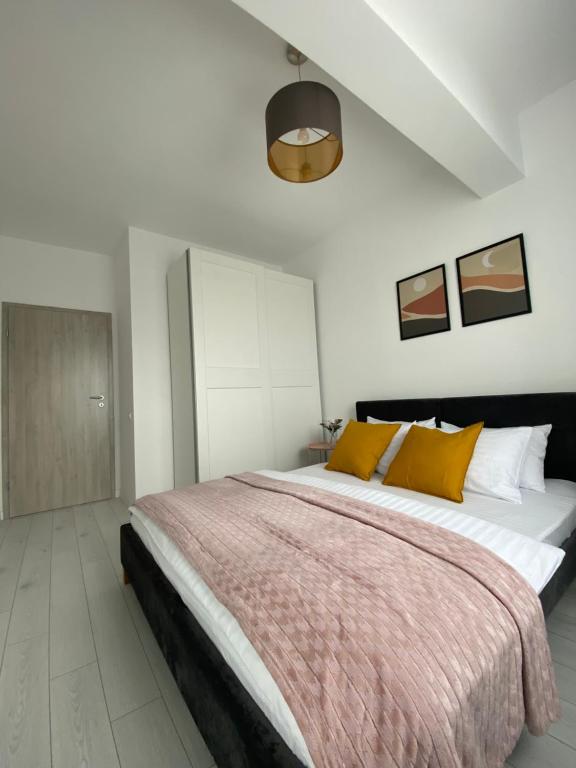 布加勒斯特Orhideea Central Apartments的一间卧室配有一张带黄色枕头的大床
