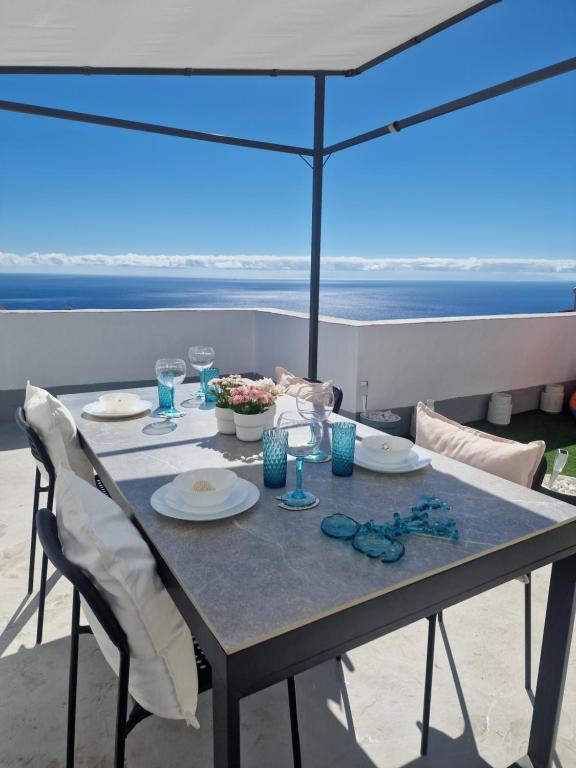 圣克鲁斯-德特内里费Ático Micaela. Terraza y vistas的餐桌,带食物盘和雨伞