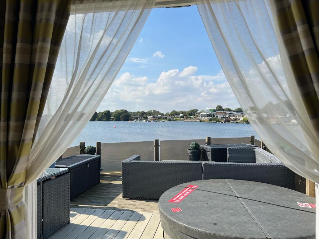 塔特舍尔Lake View with Private Hot Tub at Tattershall Lakes的一个带桌子并享有水景的庭院