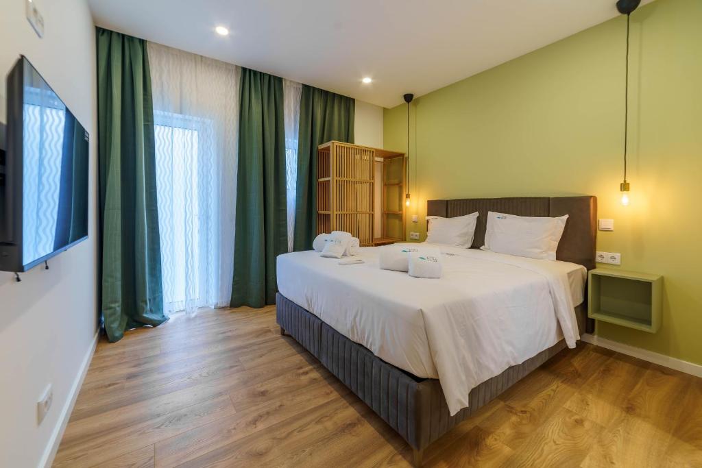 阿尔布费拉Atlantic Bliss的卧室配有带绿色窗帘的大型白色床