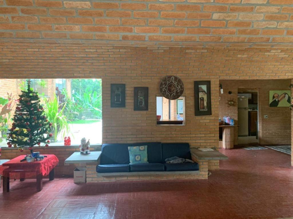 伊塔佩塞里卡-达塞拉Sítio em Itapecerica da serra的客厅设有蓝色沙发,位于砖墙内