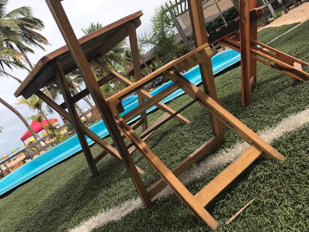 雅帕拉廷加Pousada França的游泳池旁草地上的木凳