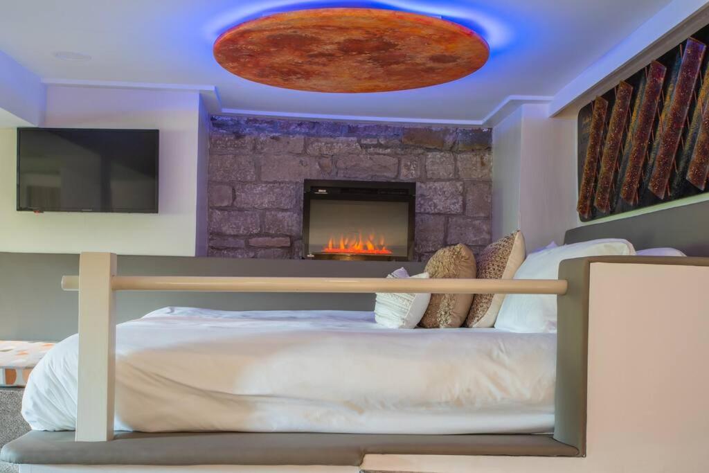 尤里卡斯普林斯NAPA Suite • Hot Tub • Downtown • Original Art的一间卧室配有一张床和一个壁炉