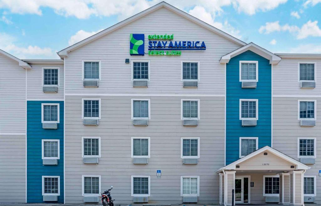 彭萨科拉Extended Stay America Select Suites - Pensacola - Northeast的一座白色的大建筑,上面有标志