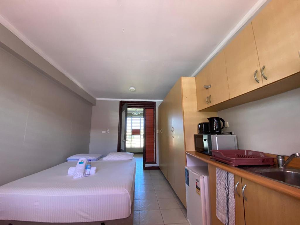苏瓦Island Travelers Accommodation的一间小房间,配有两张床和厨房