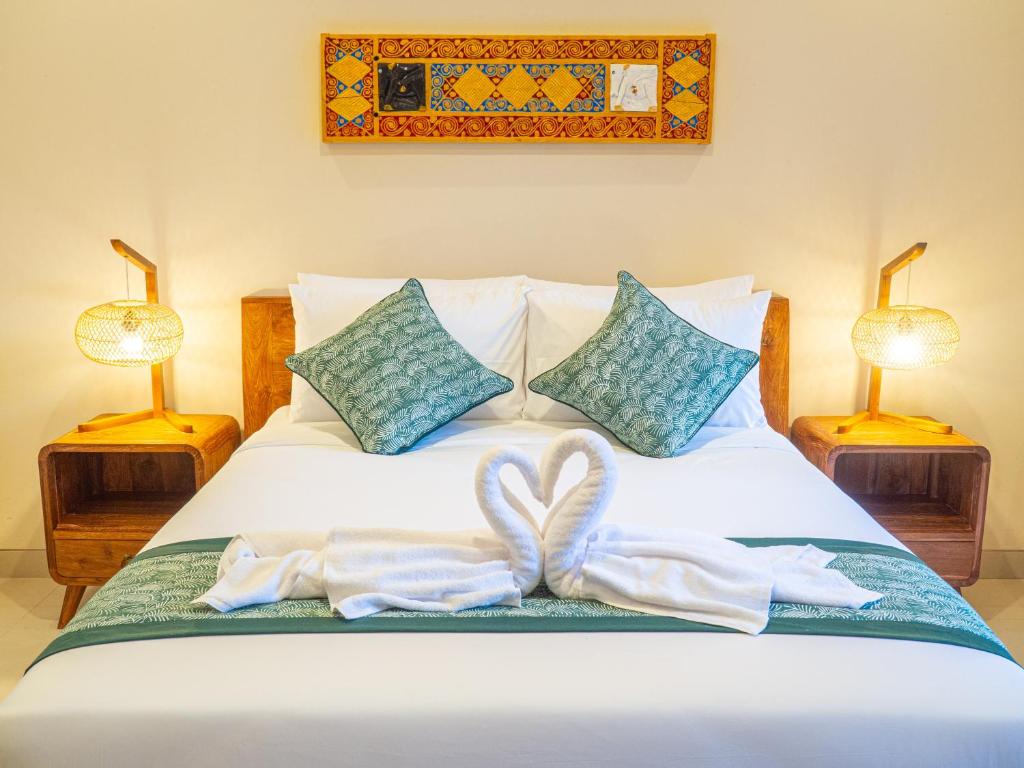 乌布Arumasta Ubud的一间卧室配有一张床、两条毛巾和两盏灯。