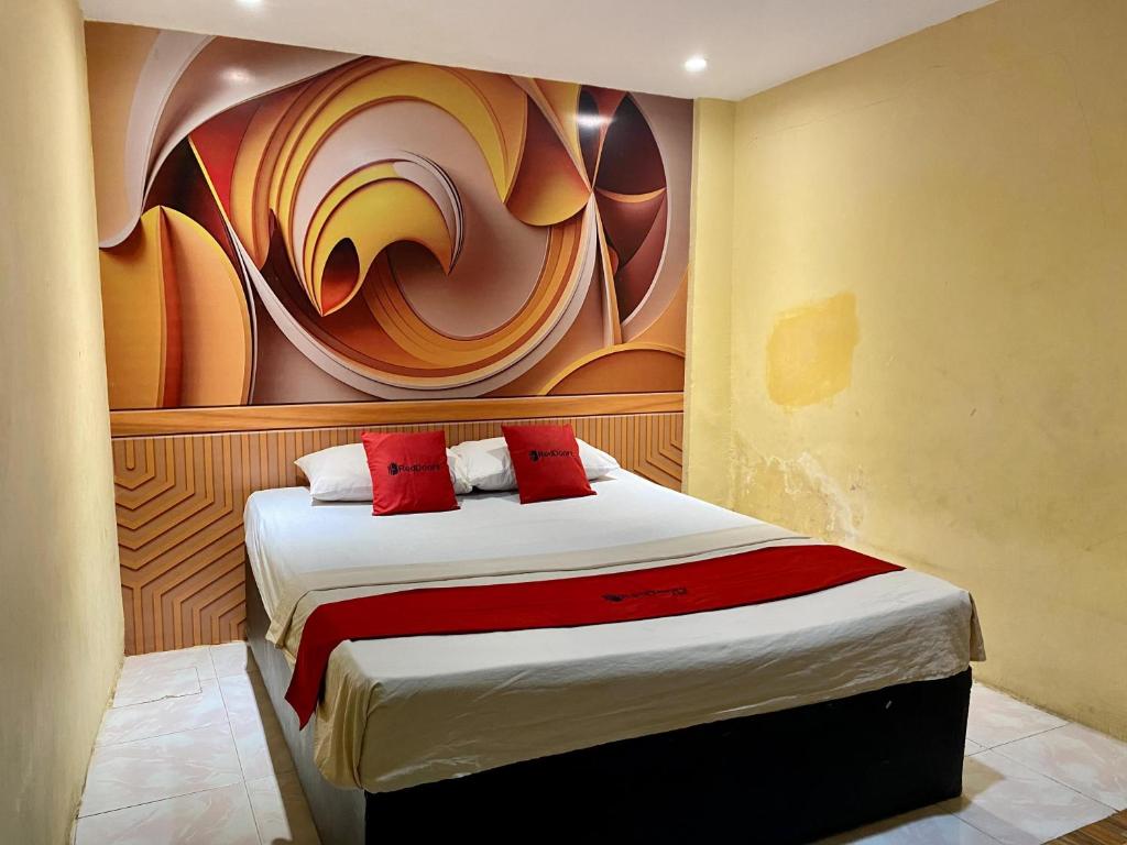 PalopoRedDoorz near Gedung Kesenian Palopo的一间卧室配有一张壁画床