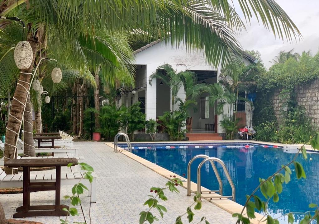 富国GREENSPACE RESORT PHUQUOC的一个带游泳池的度假胜地和一个带棕榈树的房子
