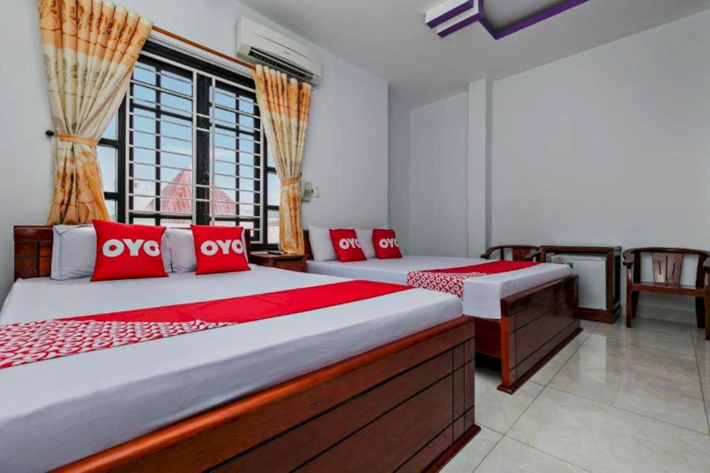 岘港OYO 998 Loan Anh 2 Hotel的一间卧室配有两张带红色枕头的床