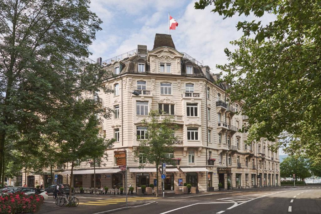 苏黎世苏黎世小型豪华大使酒店的一座白色的大建筑,上面有吊旗