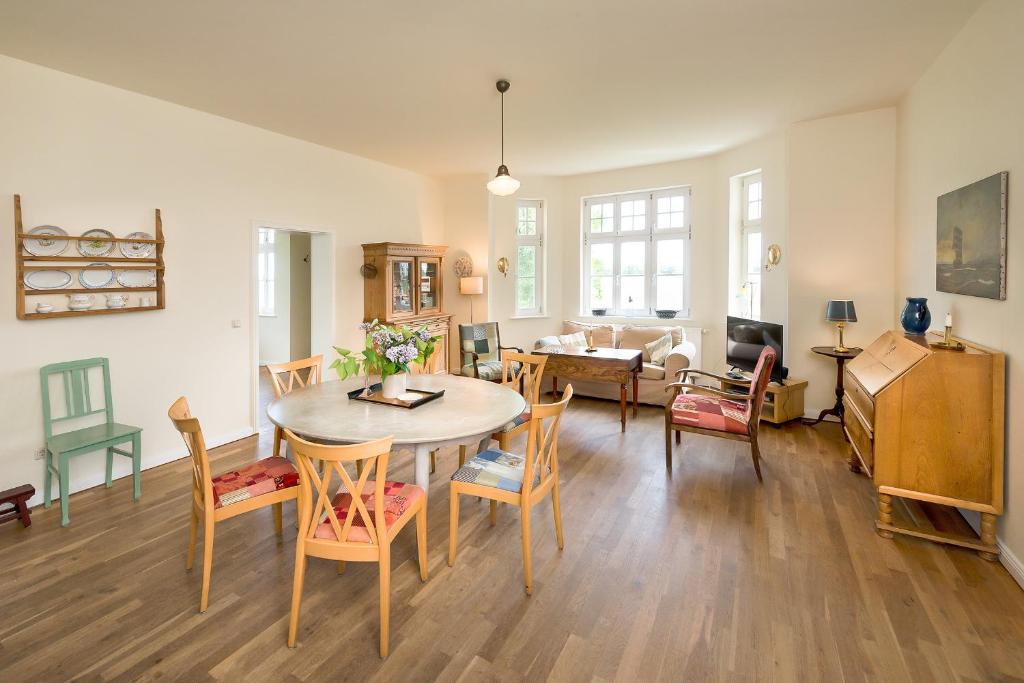 NeuenkirchenFerienwohnung 3 mit gr Terrasse und Wasserblick的用餐室以及带桌椅的起居室。