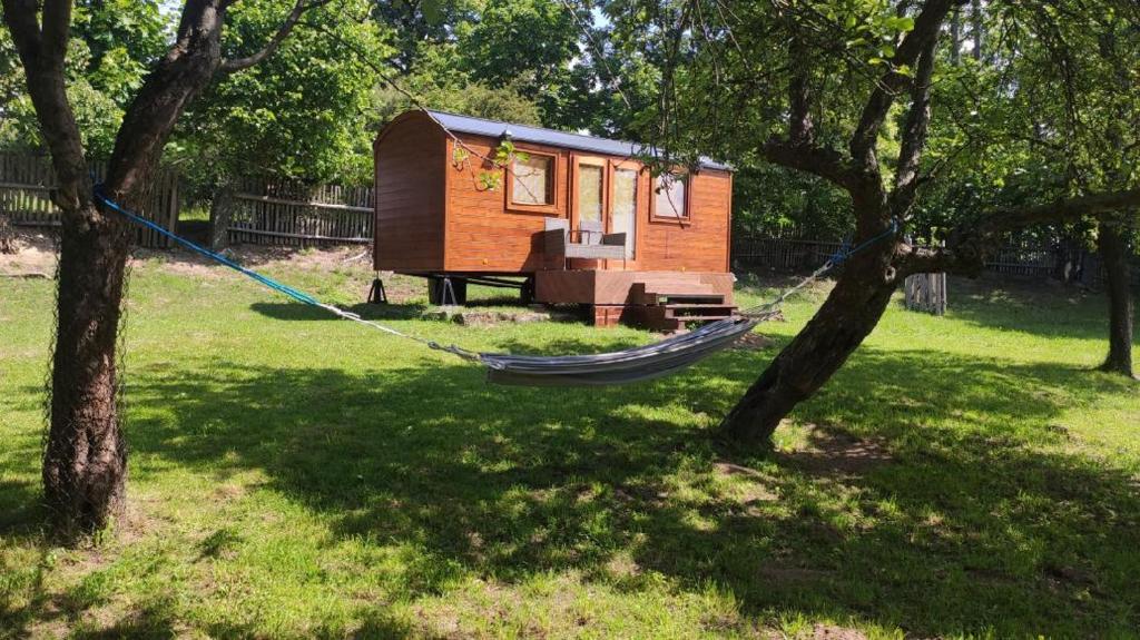 VěstoňoviceMaringotka/tiny house SEN VYSOČINA的吊床挂在两棵树之间的院子