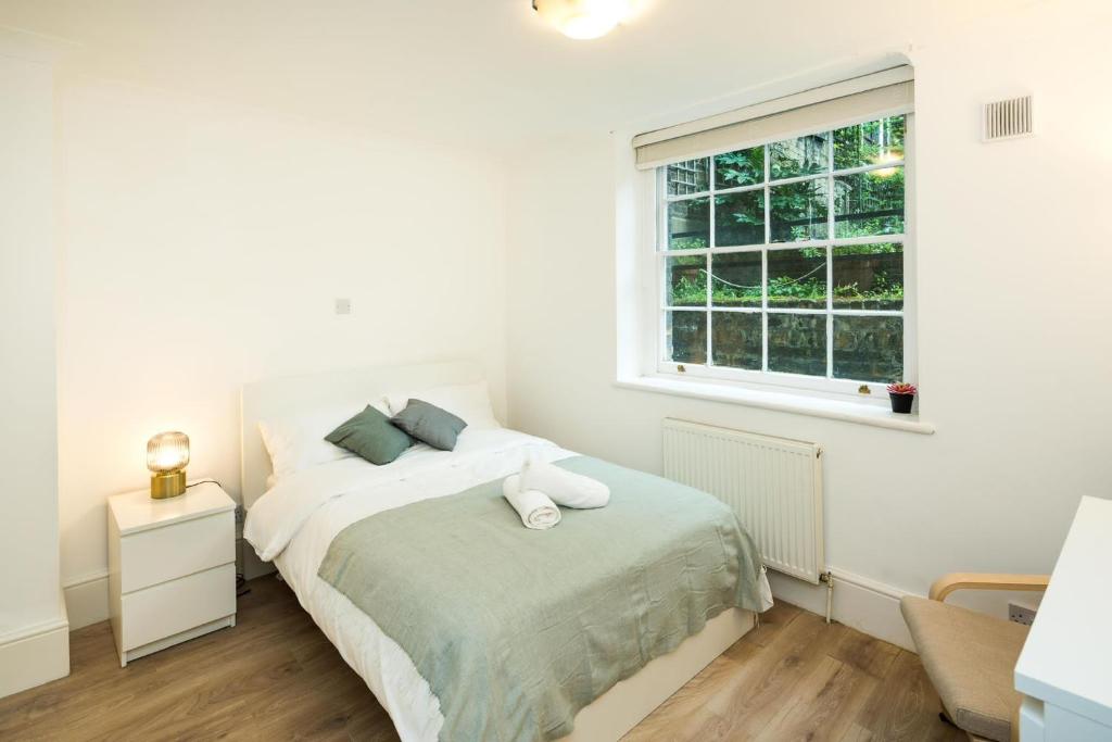伦敦Cozy 1 bedroom at Notting Hill的白色的卧室设有床和窗户