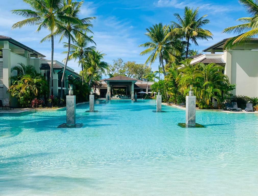 道格拉斯港Paradise Escape - Poolside Ground Floor - Sea Temple Resort and Spa的棕榈树度假村中心的一个游泳池
