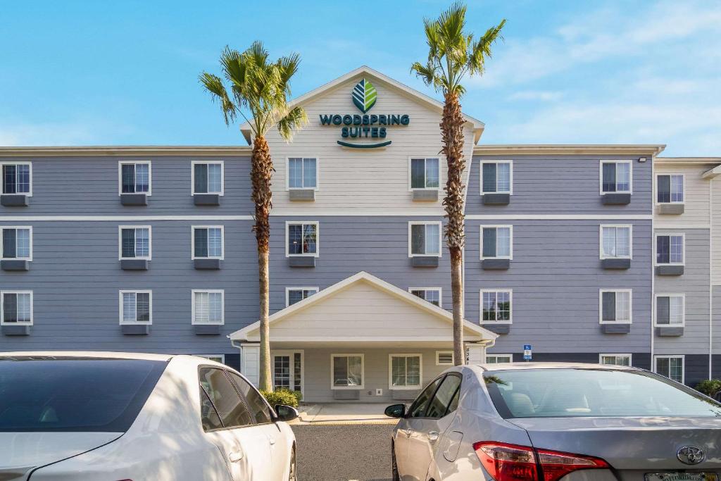 杰克逊维尔WoodSpring Suites Jacksonville I-295 East的前面有两辆车的酒店