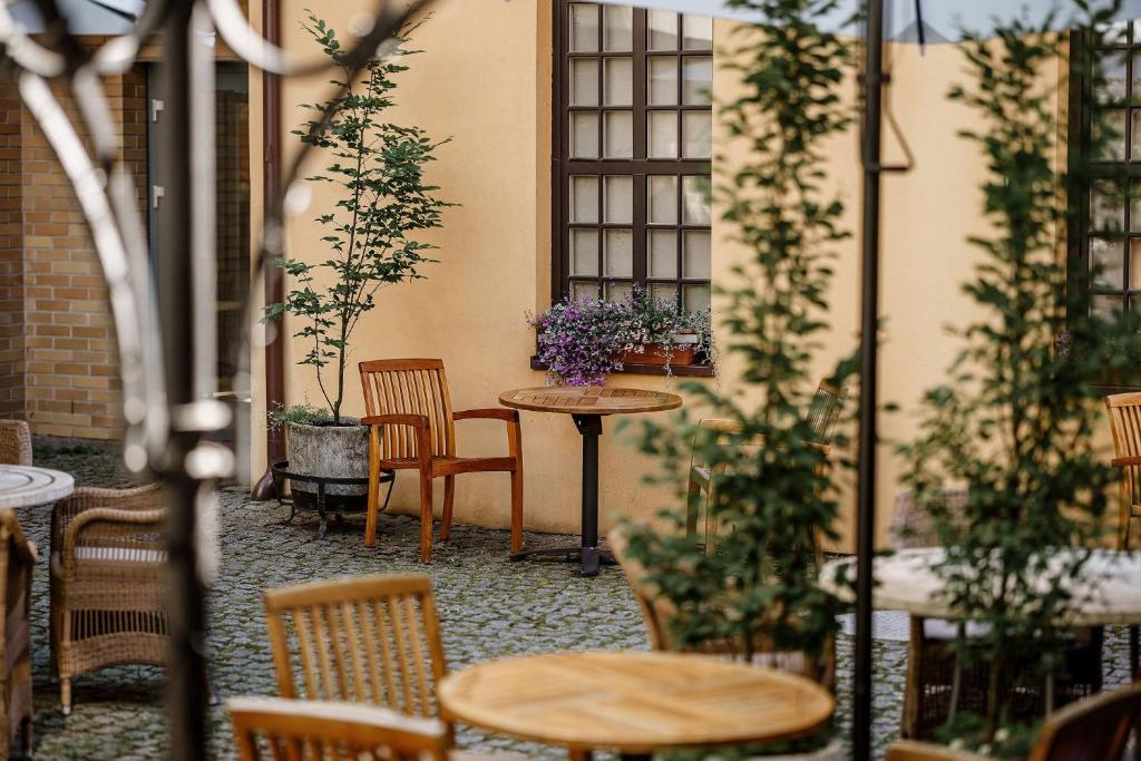 克莱佩达Euterpe Hotel的一个带桌椅和植物的庭院