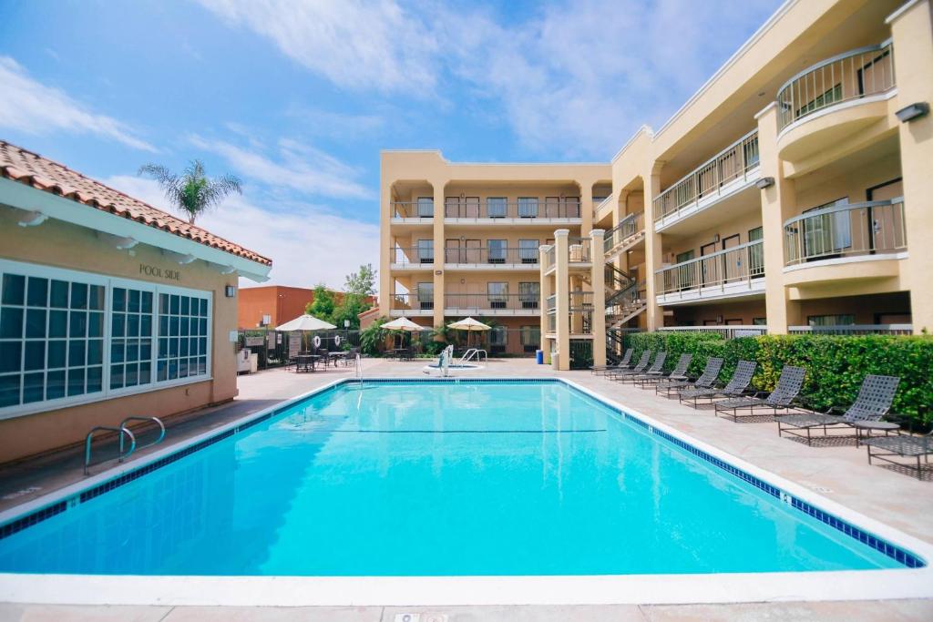 安纳海姆阿纳海姆山桔县费尔菲尔德客栈的一座游泳池位于酒店前方,设有椅子和一座建筑