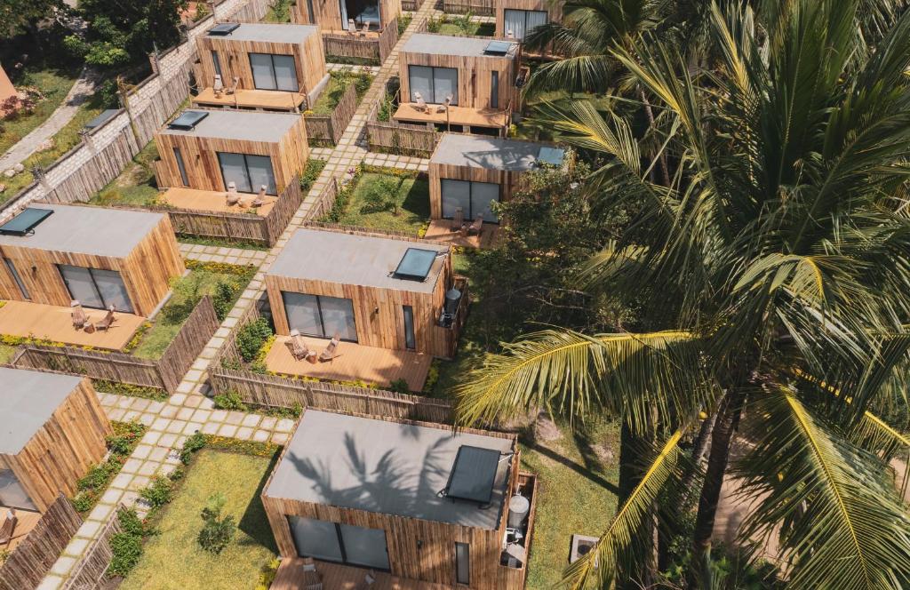 迪亚尼海滩LalaGalu - Beachfront EcoCabins的棕榈树一排的房子的顶部景色