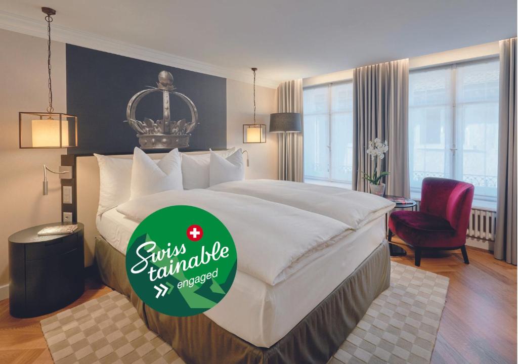 温特图尔索莱尔科隆酒店的酒店客房设有一张大床,上面有标志