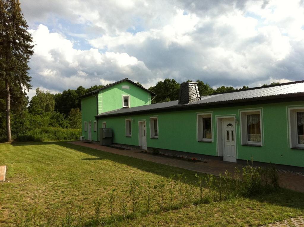 韦森贝格Ferienwohnung am Heegesee的前面有院子的绿色房子