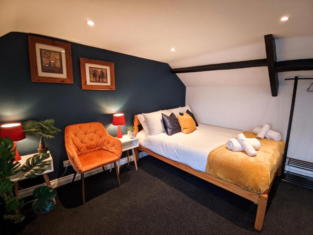 桑德兰A&A Luxury Stay Olive St - City Centre Premium Stays的一间卧室配有一张床和一张橙色椅子