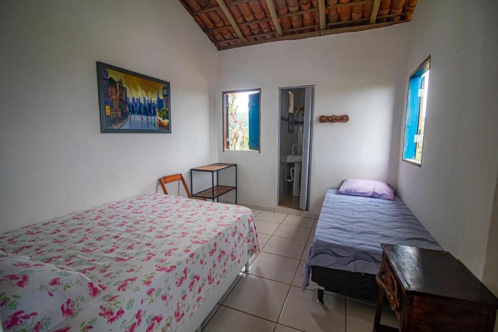 伦索伊斯Hostel Zig Zag Suítes的卧室配有床、桌子和窗户。
