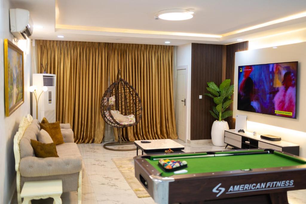 拉各斯Gerdette Luxury Apartment的客厅设有台球桌和电视。