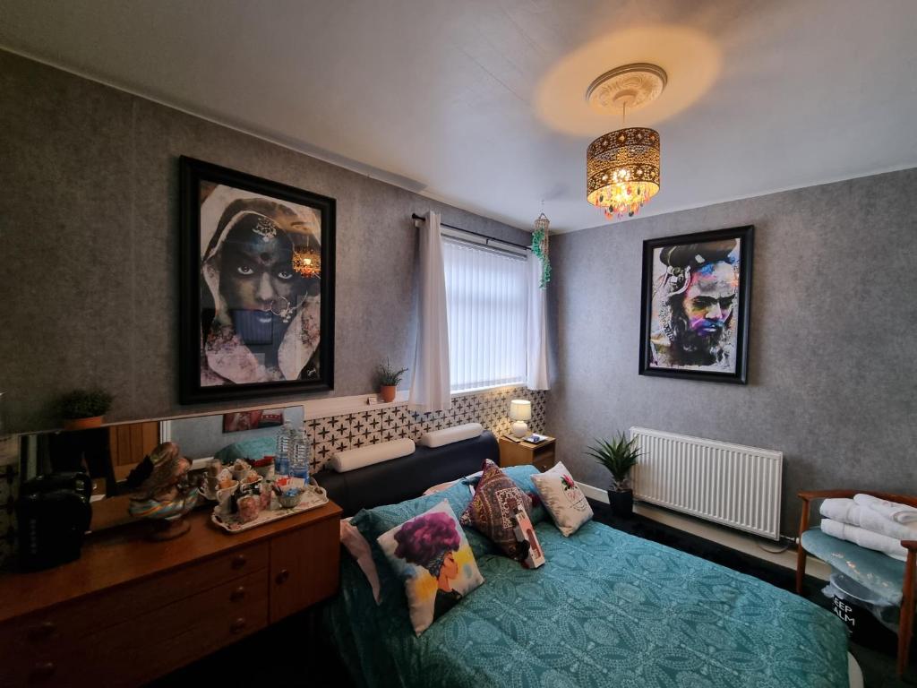 布莱克浦TIFFY'S PLACE Adult Guest House的一间卧室配有一张床、一张书桌和一个吊灯。