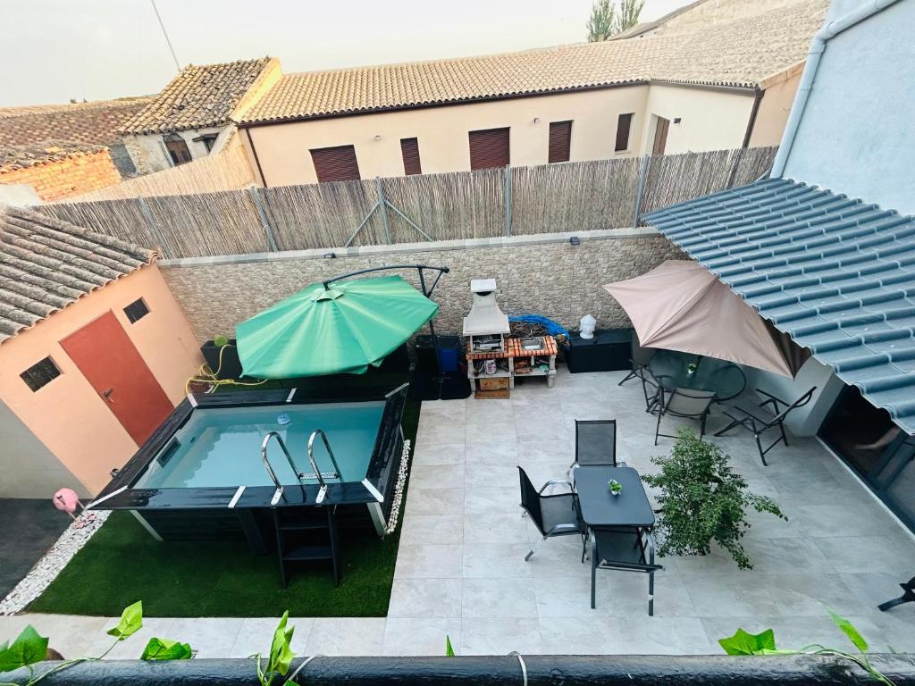 CASA BOUTIQUE LOS MONEGROS的享有带游泳池和遮阳伞的天井的顶部景致