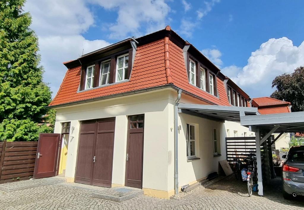 德累斯顿dresdnerferienwohnung - apartment am großen garten的一座房子,设有两个车库门和红色屋顶