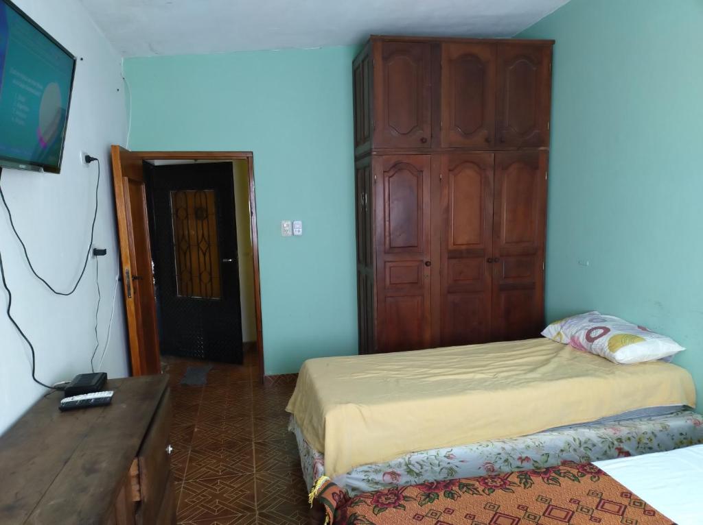 特尔马斯德里奥翁多yusulpayki的一间卧室配有一张带木柜的床和一台电视。