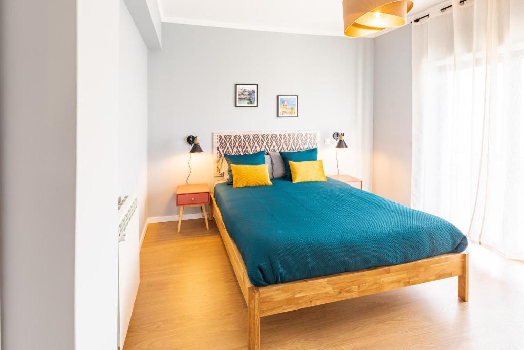 法蒂玛Modern 3 bedrooms 3 bath apartment 5 minutes walk from the Santuary的一间卧室配有一张带蓝色床单和黄色枕头的床。
